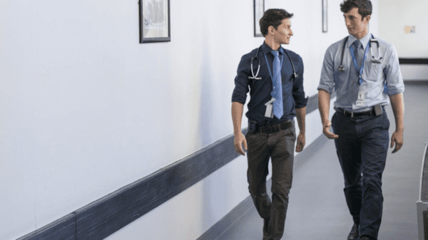 Two male doctors walking through a hospital corridor
